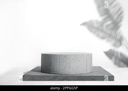 Betonpodium, Steinsockel und Handfläche hinterlässt Schatten auf hellgrauem Hintergrund, Kopierbereich. Schablone i für die Anzeige von Kosmetik- oder Hautpflegeprodukten Stockfoto