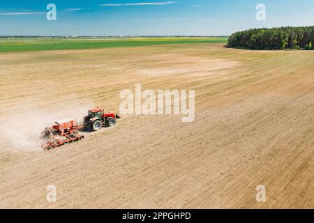 Luftaufnahme. Traktor Mit Samenbohrmaschine, Der Im Frühjahr Samen Für Erntegut Aussät. Beginn Der Landwirtschaftlichen Frühjahrssaison. Landschaftsbild Ländlicher Felder Stockfoto