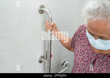 Asiatische ältere oder ältere alte Dame Frau Patienten verwenden Toilette Badezimmer Griff Sicherheit in Krankenpflege-Station, gesund starke medizinische Konzept. Stockfoto