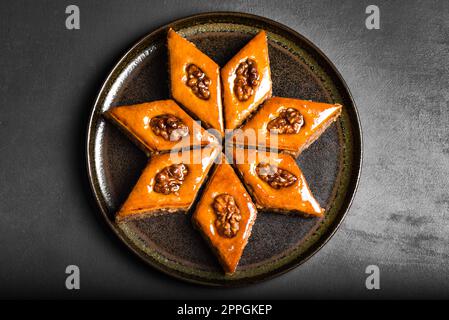 Arabisches Baklava mit Walnüssen und Honig aus nächster Nähe. Ramadan Dessert - frisches Nuss-Baklava. Stockfoto