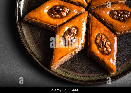 Arabisches Baklava mit Walnüssen und Honig aus nächster Nähe. Ramadan Dessert - frisches Nuss-Baklava. Stockfoto