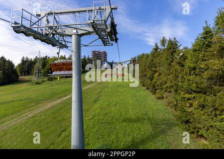 Blick auf den Sessellift zum Berg mit Aussichtsturm auf dem Gipfel des Skibahnhofs så‚otwiny Arena, Krynica Zdroj, Beskid Mountains, Slotwiny, Polen. Stockfoto