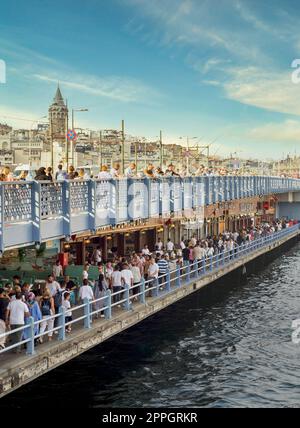 Fischrestaurants an der überfüllten Galata Bridge, während des Siegesfeiertages mit Galata Tower am anderen Ende, Istanbul, Türkei Stockfoto
