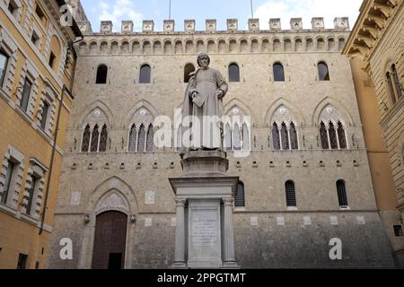 SIENA, ITALIEN - 22. JUNI 2022: Palazzo Salimbeni, Hauptbüro oder Hauptquartier der Monte dei Paschi Bank, mit Statue der Sallustio Bandini Stockfoto