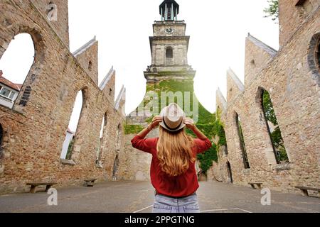 Tourismus in Deutschland. Touristenmädchen besucht die Ruinen der Aegidienkirche-Kirche, die während des Bombenanschlags auf den Zweiten Weltkrieg in Hannover zerstört wurde. Stockfoto