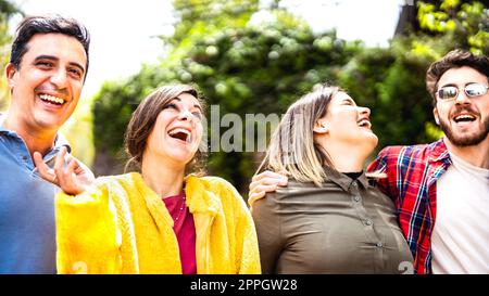 Freunde im gemischten Alter, die gemeinsam an einem echten Lifestyle-Konzept teilhaben - glückliche Männer und Frauen, die Spaß haben, im öffentlichen Stadtpark zu jubeln - Soziales g Stockfoto