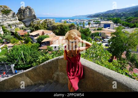 Urlaub in Tropea, Italien. Rückansicht der schönen Mode Frau steigt Treppen im Dorf Tropea, Kalabrien, Italien. Stockfoto