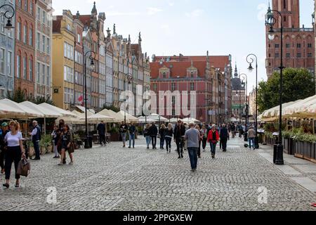 Touristen, die an einem sonnigen Tag auf dem Long Market in GdaÅ„spazieren gehen. Stockfoto
