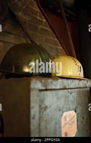Nahaufnahme der Minenhelme auf einem alten Schließfach in einer Mine im Ruhrgebiet Stockfoto