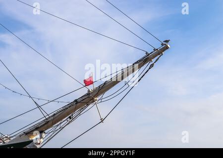 Das Segelschiff wird auf einigen Segelbooten gegen den blauen Himmel angemastet, mit Anschlagvorrichtungen. Stockfoto