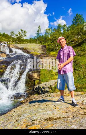 Mann Tourist vor dem wunderschönen Wasserfall Fluss Vang Norwegen. Stockfoto