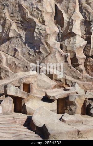 Heller grober natürlicher Steingrund. Bergbau Klippe raue Oberfläche. Großer Kalksteinstapel Hintergrund. Schwere Grunge beschädigte Granitblock Textur Stockfoto