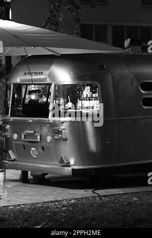 Vertikale Aufnahme eines Retro-Luftwagens als Food Truck bei Nacht in Berlin Stockfoto