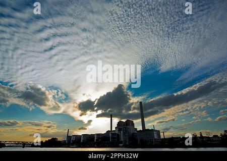 Kraft-Wärme-Kopplungsanlage gegen den dramatischen Abendhimmel am Flussufer Stockfoto