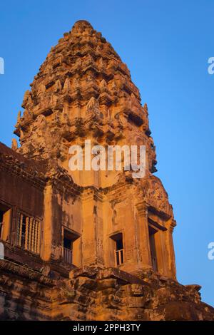 Angkor Wat, in Kambodscha. Niedriger Winkel Blick auf einen der zentralen Türme bei Sonnenuntergang vor blauem Himmel. Stockfoto