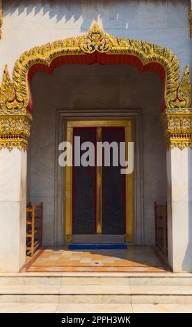 Tempel des Wat Benchamabophit, in Bangkok, Thailand. Architektonisches Detail einer verzierten goldenen Tür. Stockfoto