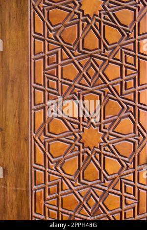 Geometrisches Muster an einer Holztür in der Sehzade-Moschee in Istanbul, Türkei. Islamische Kunst, Holzarbeiten, Details im Detail. Stockfoto