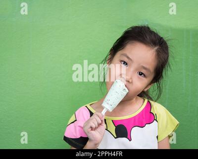 Ein asiatisches Mädchen isst im Sommer Eis Stockfoto