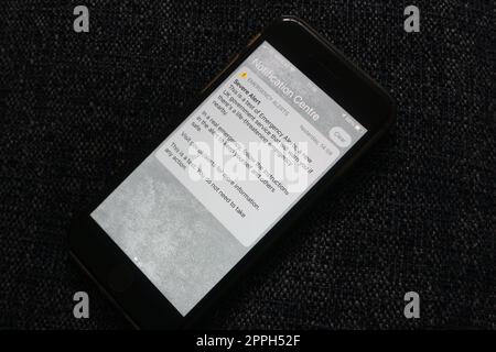 Der erste Notfalltest, der von allen Mobiltelefonen in Großbritannien empfangen wurde, wird im april 2023 auf einem iphone-Display gezeigt Stockfoto