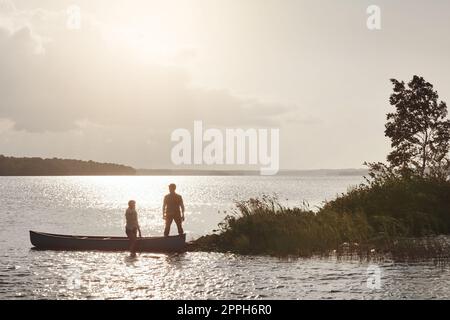 Kanufahren stärkt ihre Verbindung. Ein junges Paar, das eine Kanufahrt auf dem See macht. Stockfoto