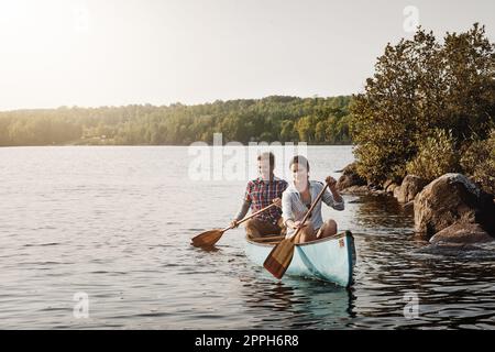 Das Leben ist eine entspannende Kanufahrt. Ein junges Paar, das eine Kanufahrt auf dem See macht. Stockfoto