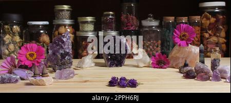 Amethyst-Kristalle und Blumen auf dem Meditationstisch Stockfoto