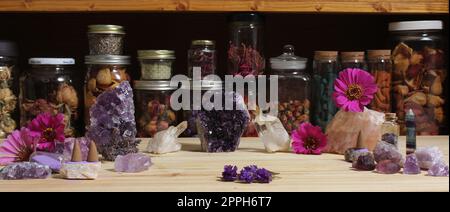 Amethyst-Kristalle und Blumen auf dem Meditationstisch Stockfoto