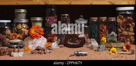 Agatisierte Koralle mit Quarzkristallen und Blumen mit australischem rotem Sand auf Meditationstisch Stockfoto