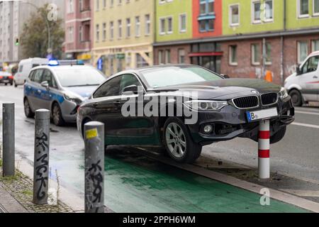 In den frühen Morgenstunden stieß ein Pkw auf die Poller einer Fahrradstrecke im verkehrsberuhigten HermannstraÃŸe (Geschwindigkeit 30 km/h) in Berlin und erlitt erhebliche Schäden am Unterboden und Motorraum. Der Fahrer floh und verließ das Fahrzeug Stockfoto