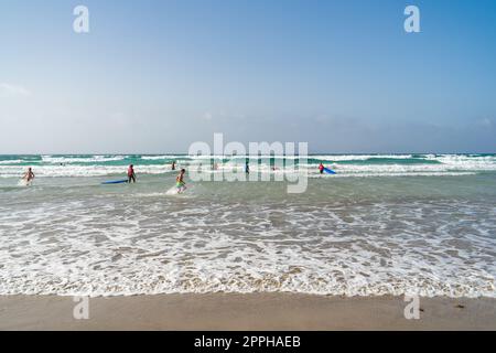 FAMARA BEACH LANZAROTE, KANARISCHE INSELN - 21. JULI 2022: Surfer auf den Wellen. Famara Beach (Playa de Famara), beliebter Surfstrand auf Lanzarote. Stockfoto