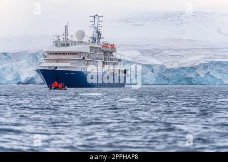 Expeditionsschiff vor der antarktischen Eisbergslandschaft in Cierva Cove auf der Westseite der antarktischen Halbinsel Stockfoto