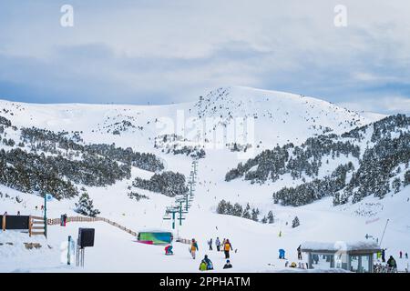 Eine Gruppe von Personen, Skifahrern und Snowboardern, die in den Pyrenäen, Andorra, einen Skilift nehmen Stockfoto