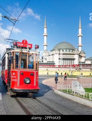 Nostalgische rote Straßenbahn Taksim Tunel, oder Tramvay, mit Taksim-Moschee im Hintergrund, am Taksim-Platz, Istanbul, Türkei Stockfoto