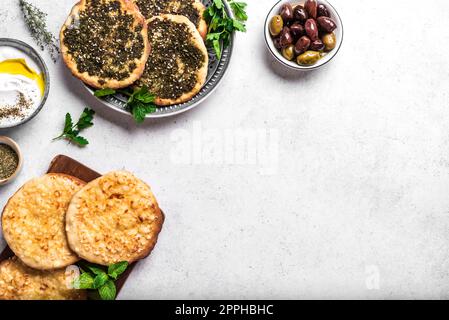 Arabisches Frühstück, LabNO-Joghurt, Manakeesh- oder Pita-Brot mit Käse und Zaatar auf weißem Tisch, Kopierbereich. Nahöstliche Küche, arabische Küche. Stockfoto