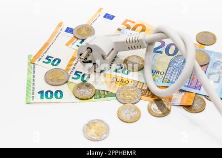 Das geknotete Stromkabel auf Euro-Banknoten und -Münzen. Konzept steigender Strompreise Stockfoto