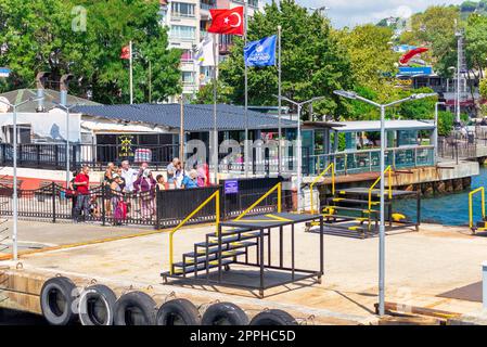 Bosporus, Sariyer Ferry Terminal mit wartenden Passagieren und dichten grünen Bäumen, Istanbul, Türkei Stockfoto