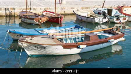 Kleine Fischerboote und Ausflugsboote der Einwohner der Stadt Krk am Hafen an der kroatischen Küste der Adria Stockfoto