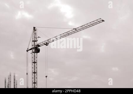 Abstrakte industriellen Hintergrund mit dem Bau von Turmdrehkranen über klaren blauen Himmel. Baustelle. Gebäude im Bau Konzept. Retro Ton Stockfoto