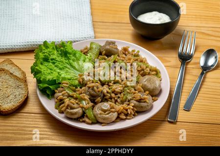 Risoni Pasta - Linsen und Kichererbsen mit Pilzen, knusprig gebratene Zucchini und Salat Stockfoto