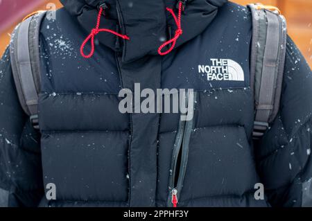 Moskau, Russland - 01. März 2022: Schwarze Jacke des Unternehmens „The North Face“ mit Nahaufnahme-Logo, im Winter. Bekleidungskollektion „Summit Series“. Mann, der Mann trägt die North Face Jacke. Stockfoto