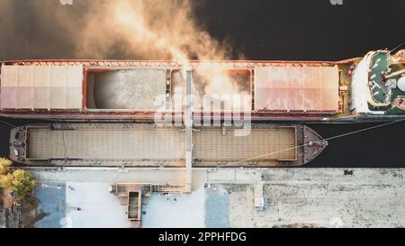 Draufsicht von der Drohne eines großen Schiffes, das Getreide für den Export verladen soll. Wassertransport Stockfoto