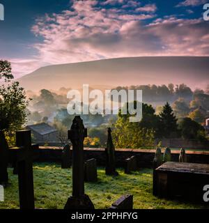 Frühmorgendlicher Nebel und niedrige Sonne über dem Dorf Downham, Ribble Valley, Lancashire, Großbritannien. Stockfoto