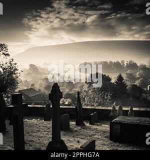 Frühmorgendlicher Nebel und niedrige Sonne über dem Dorf Downham, Ribble Valley, Lancashire, Großbritannien. Stockfoto