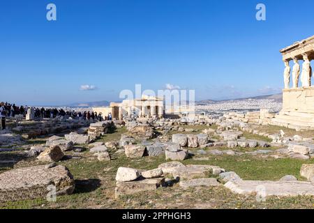 Gruppe von Touristen auf den Ruinen der Akropolis, Blick auf Erechtheion mit Karitiden und Tor Propylaia, Athen, Griechenland Stockfoto