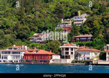 Grüne Berge auf der asiatischen Seite der Bosporus-Straße mit traditionellen Häusern und dichten Bäumen an einem Sommertag Stockfoto