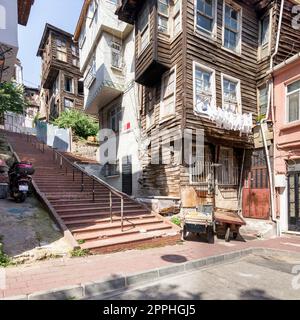 Alte traditionelle Holz- und Steinhäuser und Steintreppen im alten Balat-Viertel an einem Sommertag in Istanbul, Türkei Stockfoto