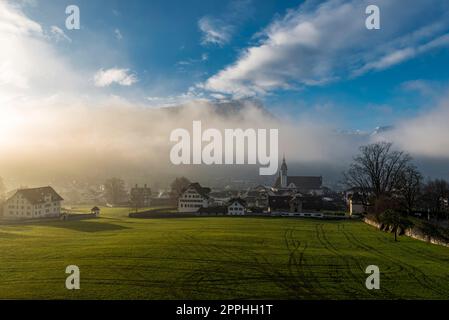 Morgentrübe oder Abendtrübe mit den Lichtstrahlen der Sonne, die sie in der Stadt Schwyz in der Schweiz durchdringen Stockfoto