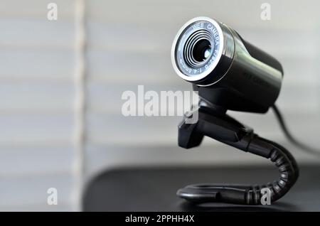 Kabelgebundene Webkamera, die auf der Computeroberfläche liegt. Nahaufnahme Stockfoto