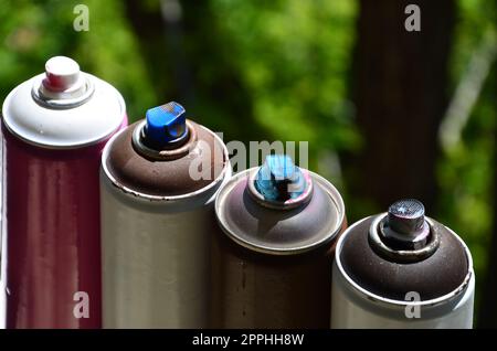 Ein paar gebrauchte Sprühgeräte mit Aerosolfarbe liegen auf der Fensterbank in der Werkstatt eines Graffiti-Künstlers. Das Konzept der Street Art und der illegalen Zeichnung an den Wänden. Jugendhobby Stockfoto