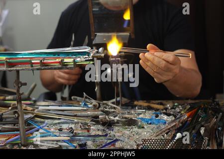 Glasarbeiter beim Formen des Glases mit einer sehr heißen Flamme Stockfoto